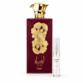 Ansaam Gold de Lattafa Pride junto a decant de cristal de 5 ml con tapón translúcido; frasco original como referencia